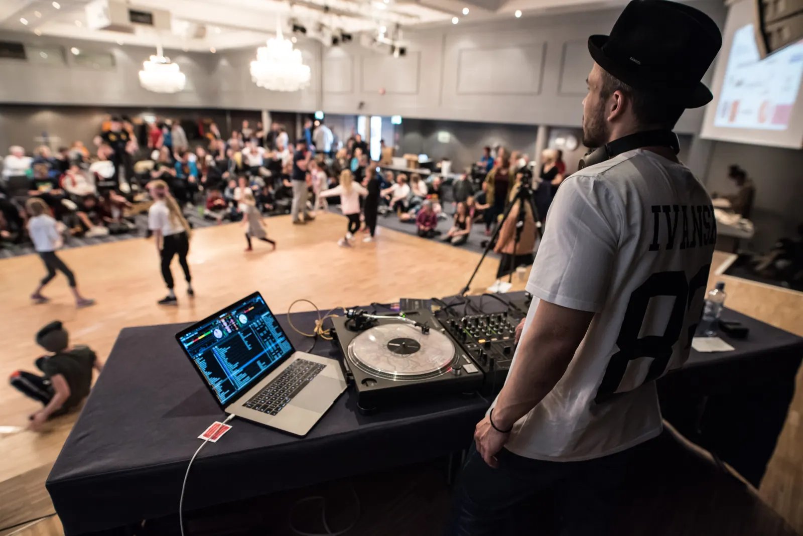 A DJ playing for a crowd of young dancers at Arctic Jam